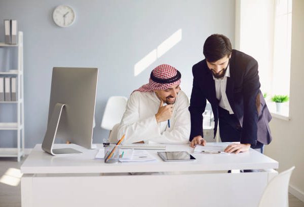 Arab and european businessman confident working in a white office. Businesspeople work startup business project merge business meeting in a modern business center.